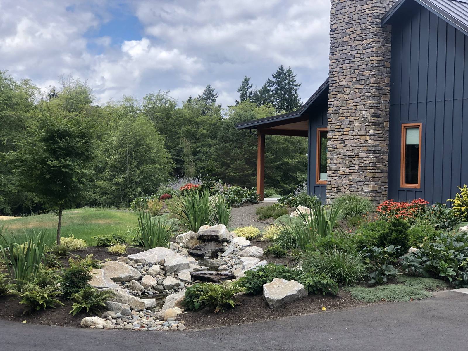 Stone cascade beneath the home's chimney and covered porch