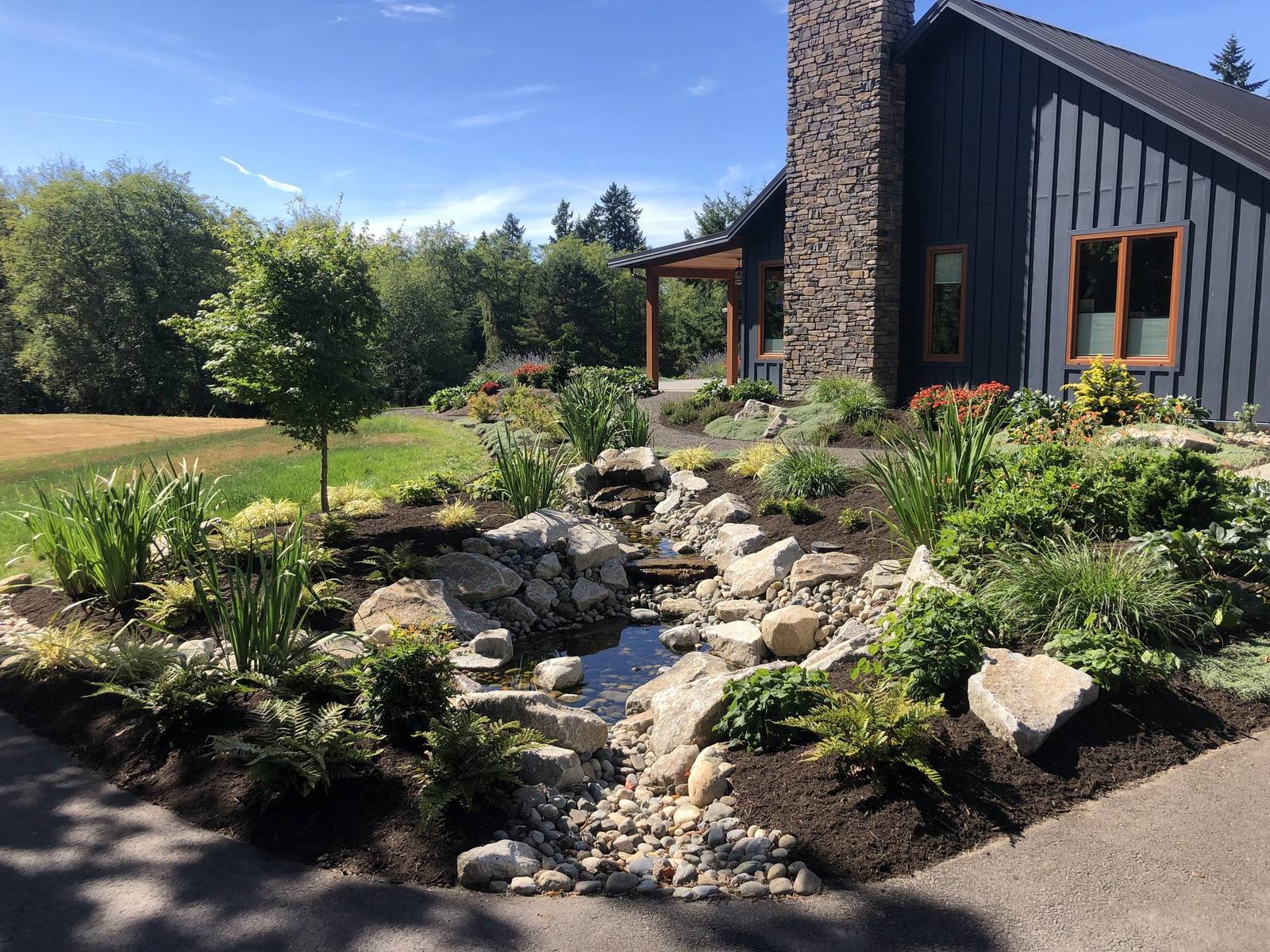 Long view of the stream flowing through the country home landscape
