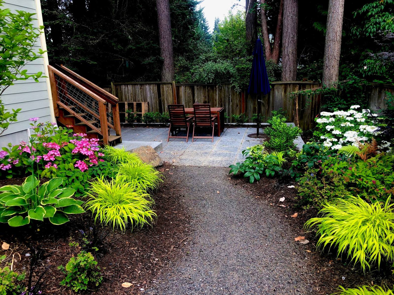 Garden path leading to a shaded stone patio