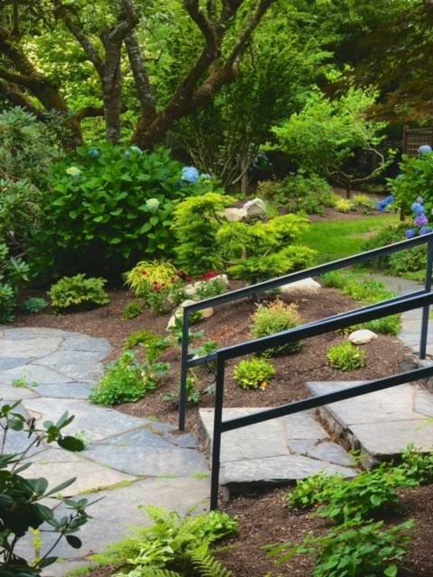 A stone path winding through a lush shaded garden